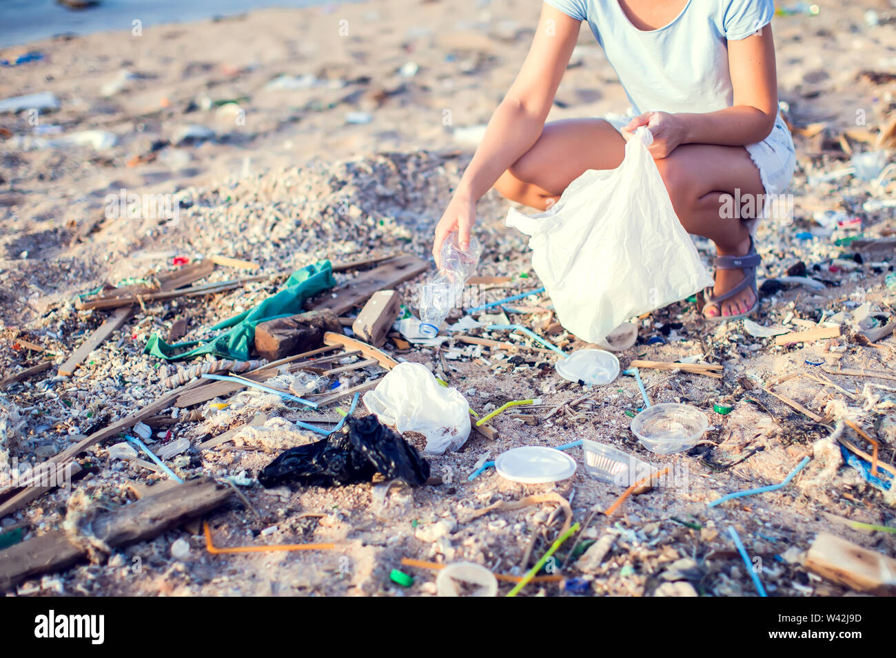 Donna raccogli garbage sulla spiaggia. La tutela ambientale concetto Foto Stock
