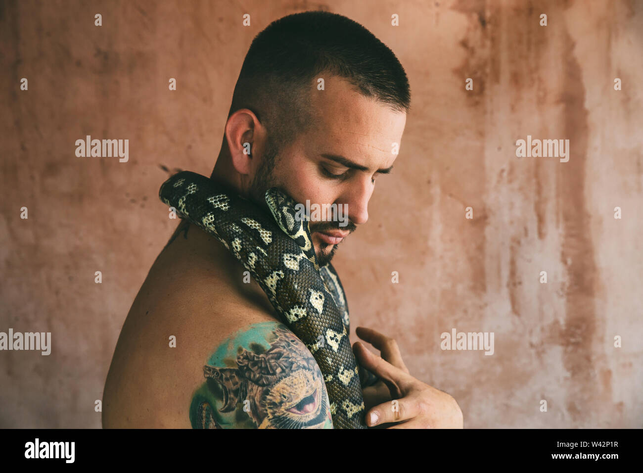 Ritratto di uomo che abbraccia un serpente Foto Stock