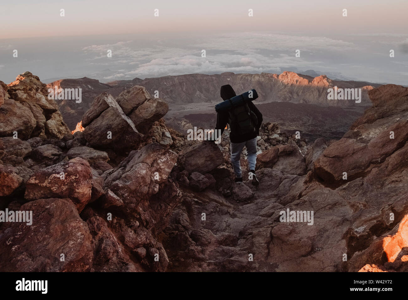 Un maschio di escursionista cammina sul sentiero sopra le nuvole a sunrise,El Teide Foto Stock