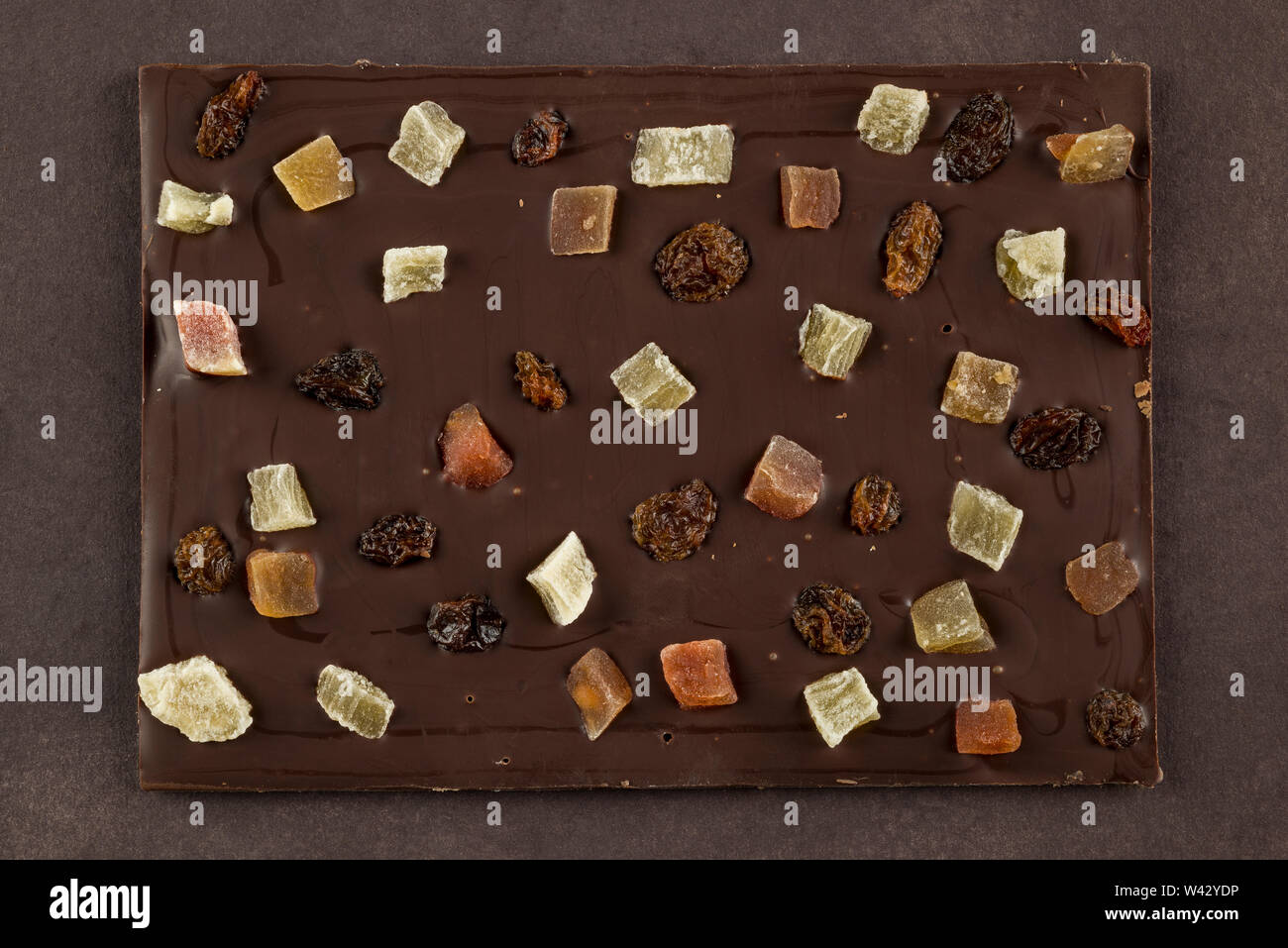 Dark chocolate bar con frutta candita su sfondo marrone Foto Stock Dark chocolate bar con frutta candita su sfondo marrone Foto Stock