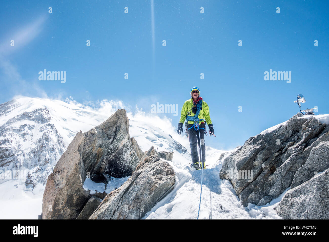 Un alpinista si eleva alto su una cresta esposta ad alta al di sopra di Chamonix Foto Stock