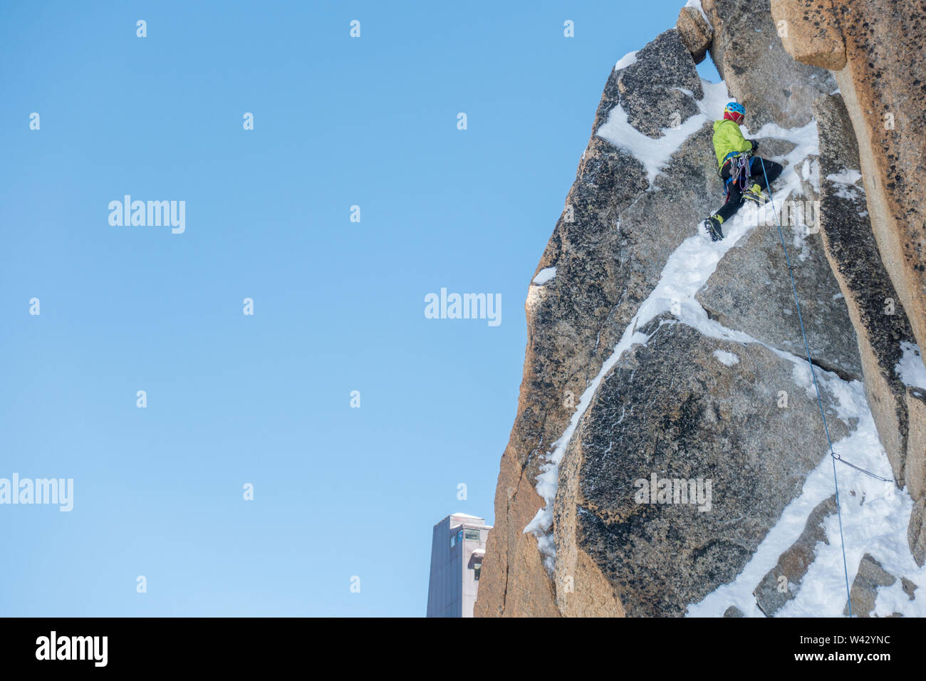 Un alpinista esaurisce il ripido terreno misto sulla Aiguille du Midi Foto Stock