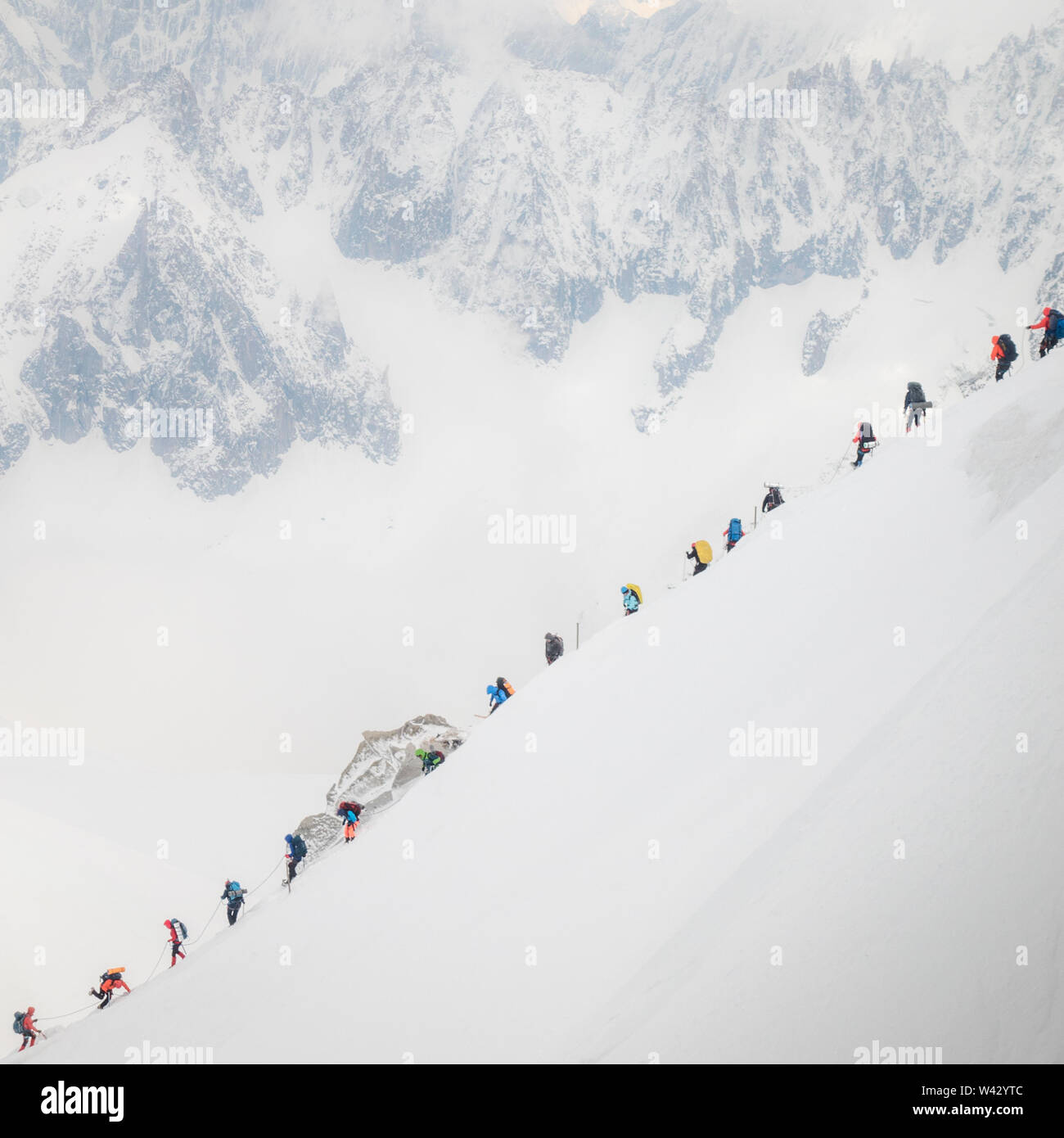 Traffico sul Mt Blanc come una stringa di scalatori navigare un ripido crinale Foto Stock