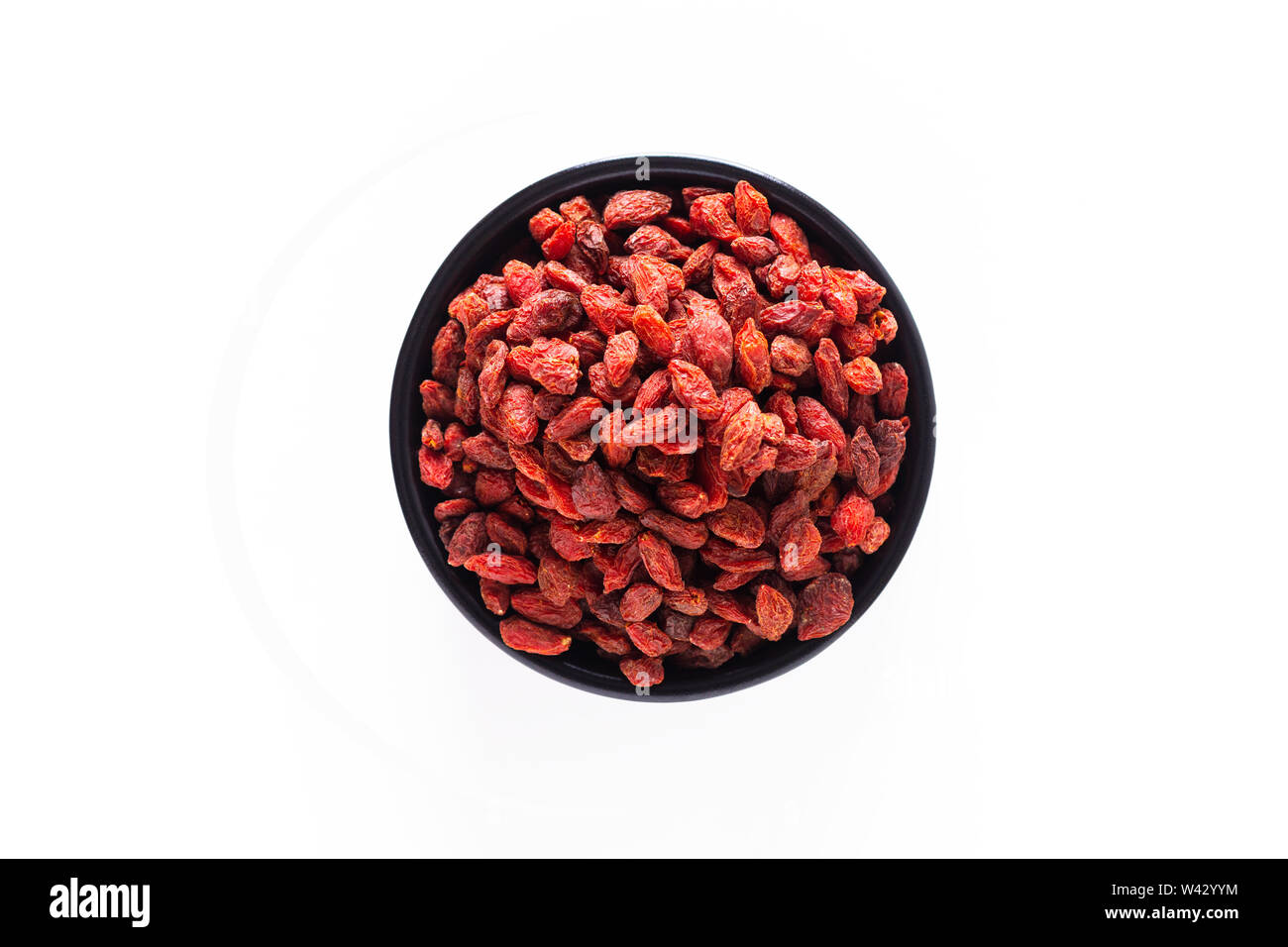 Super Brain food dry Goji berry in nero coppa in ceramica isolata su sfondo bianco con spazio di copia Foto Stock