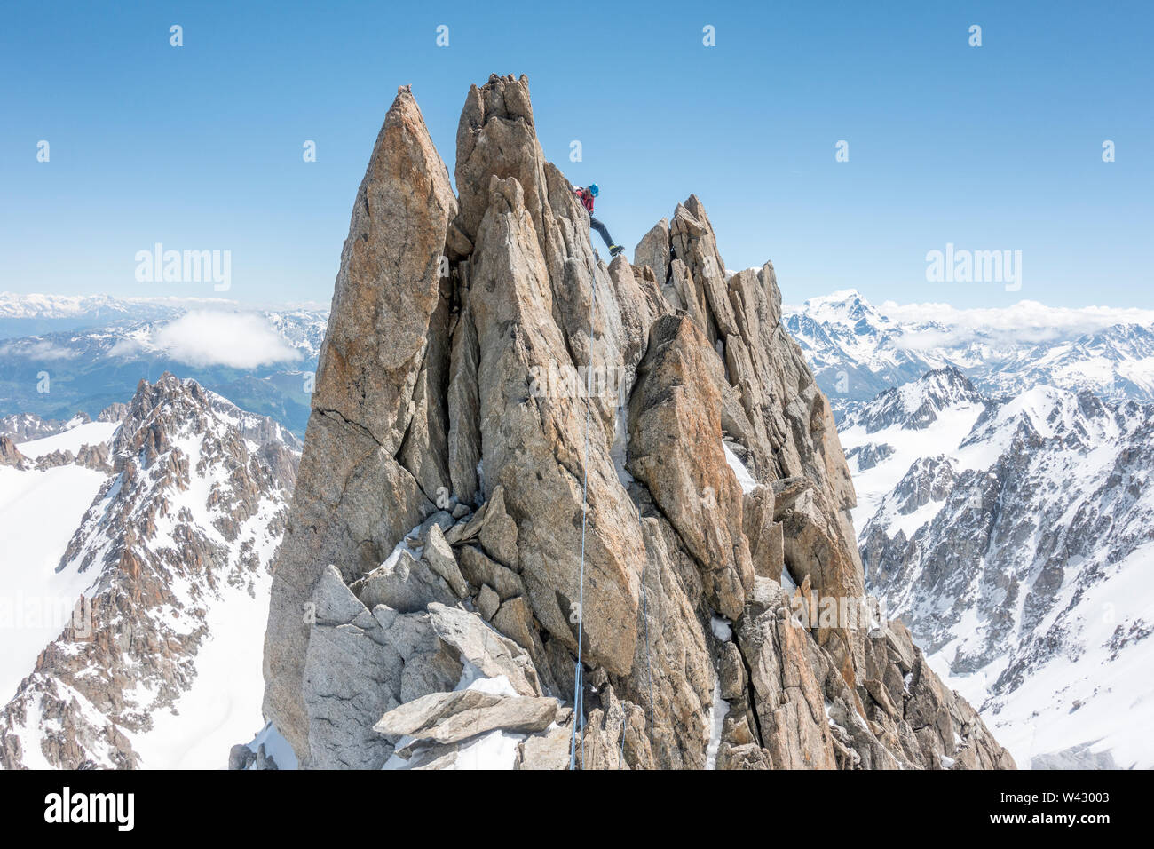 Una stagione alpinista considera suo ancora prima di iniziare un rappel Foto Stock