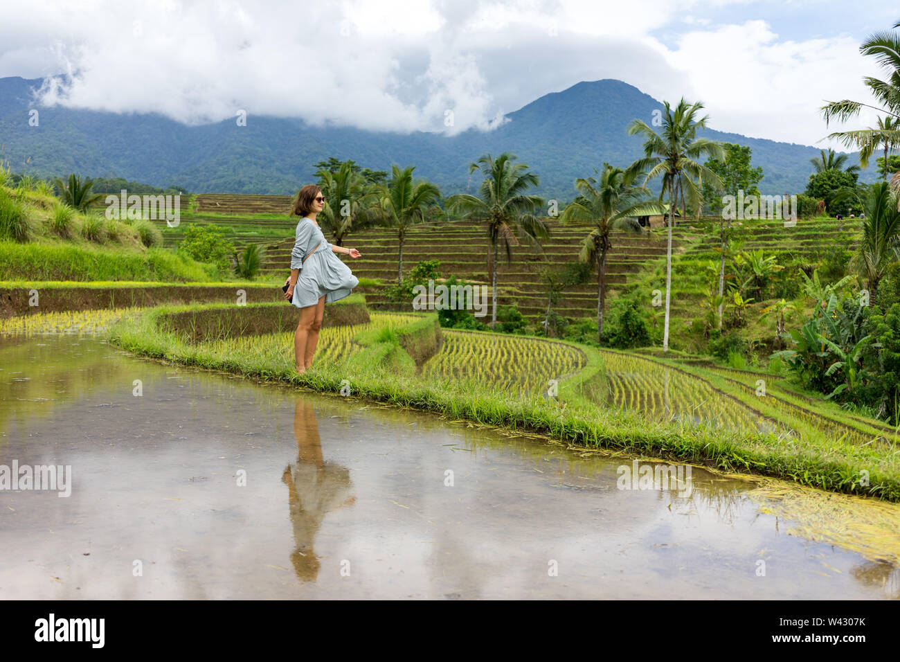 Signora giovane sta ballando in campi di riso Foto Stock