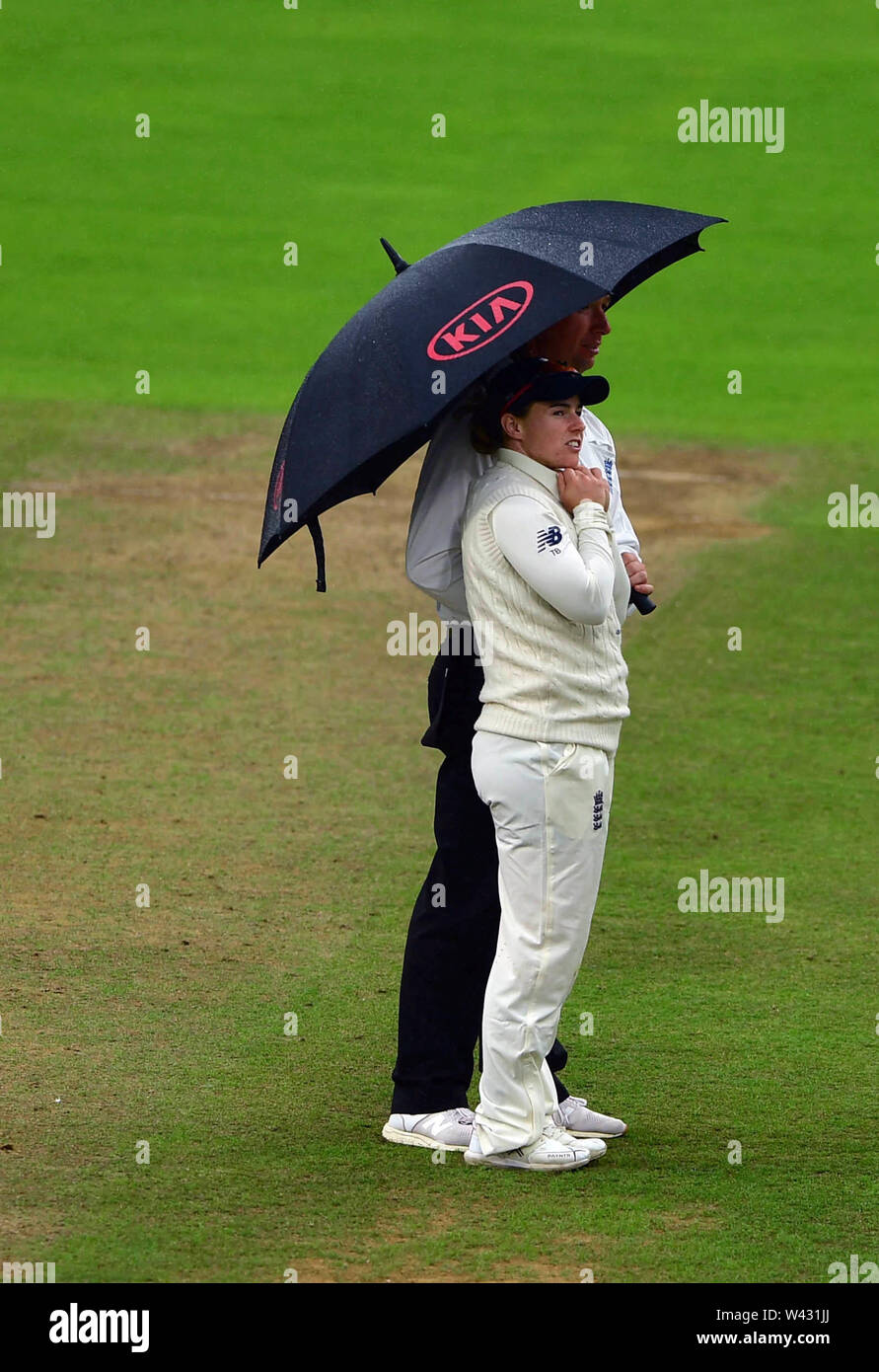 Englands Tammy Beaumont e il terzo arbitro Paolo Baldwin rifugiarsi sotto un ombrello durante il giorno Due delle donne del Ceneri Test match alla Cooper Associates County Ground, Taunton. Foto Stock