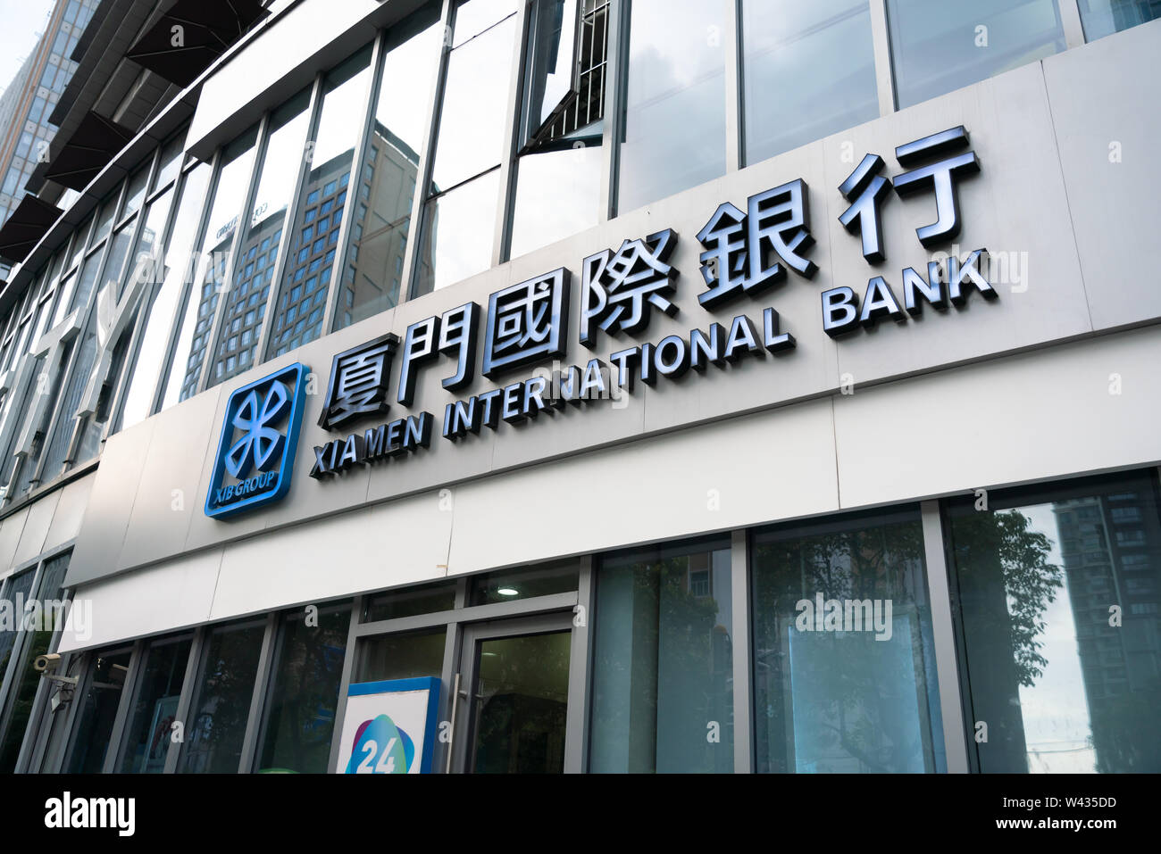Un ramo e il logo di Xiamen International Bank, la prima joint venture banca in Cina, visto in Shanghai. Foto Stock