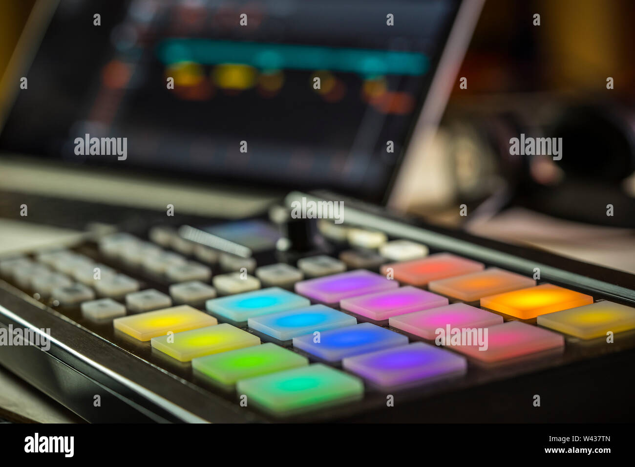 Musica elettronica produzione.Closeup di piazzole di LED su un Maschine Mikro controller midi con laptop Foto Stock