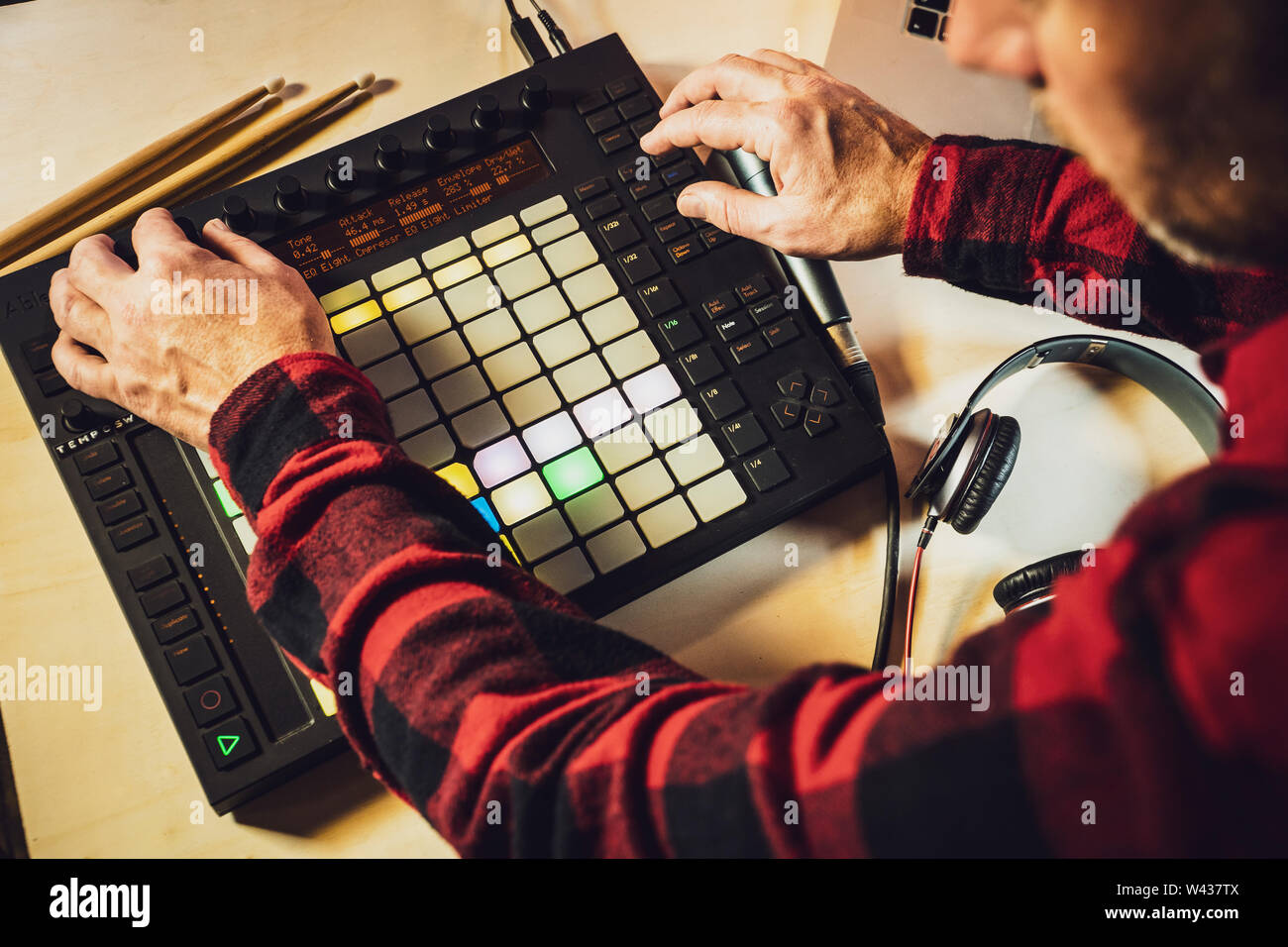 Musica elettronica di produzione. Guardando oltre la spalla di un musicista come egli utilizza un Push Ableton midi pad controller Foto Stock