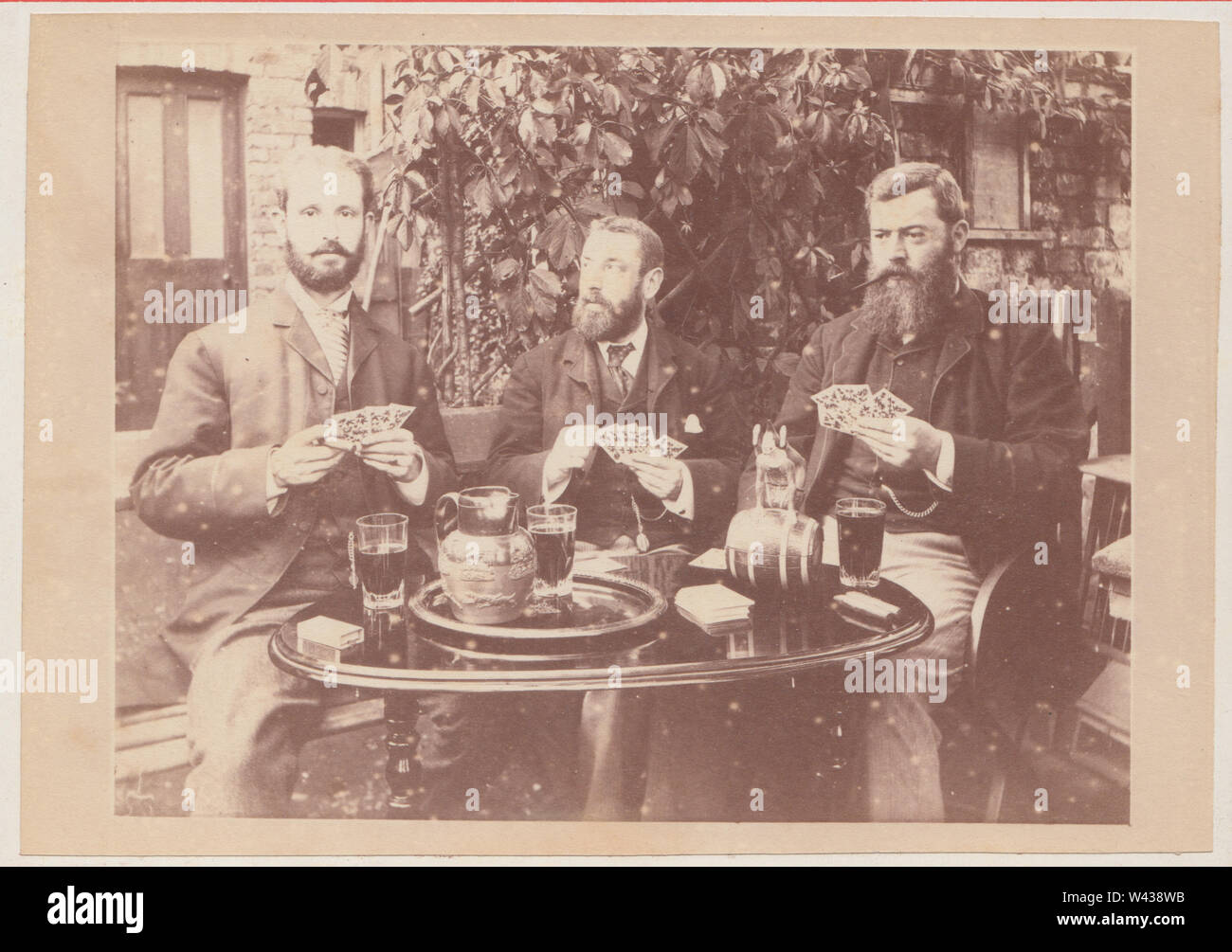 Armadio vittoriano Card che mostra un gruppo di tre uomo barbuto seduto fuori ad un tavolo. Gli uomini sono le carte da gioco (gioco d'azzardo) e il consumo di alcol. Foto Stock