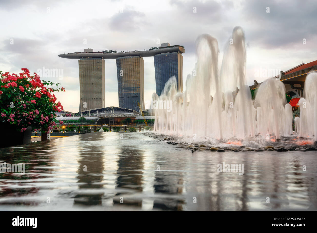 Fontana contro il futuristico Marina Bay sands hotel al tramonto in Singapore Foto Stock