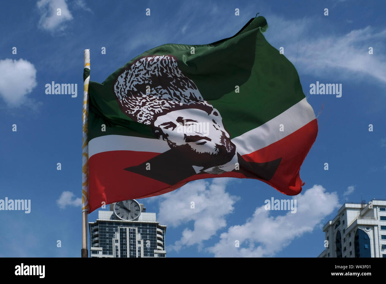 La bandiera cecena portante l'immagine di Akhmad Kadyrov ex capo della Repubblica cecena svolazzanti a Grozny la capitale della Cecenia nel Nord Caucaso Distretto federale della Russia. Foto Stock