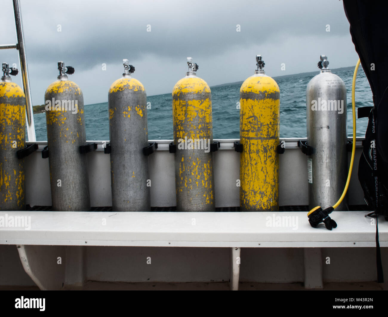 Alcuni di alta pressione serbatoi in acciaio posto su una barca di immersione nel mare di Cuba in una giornata con il rigonfiamento e orizzonte storto. Foto Stock