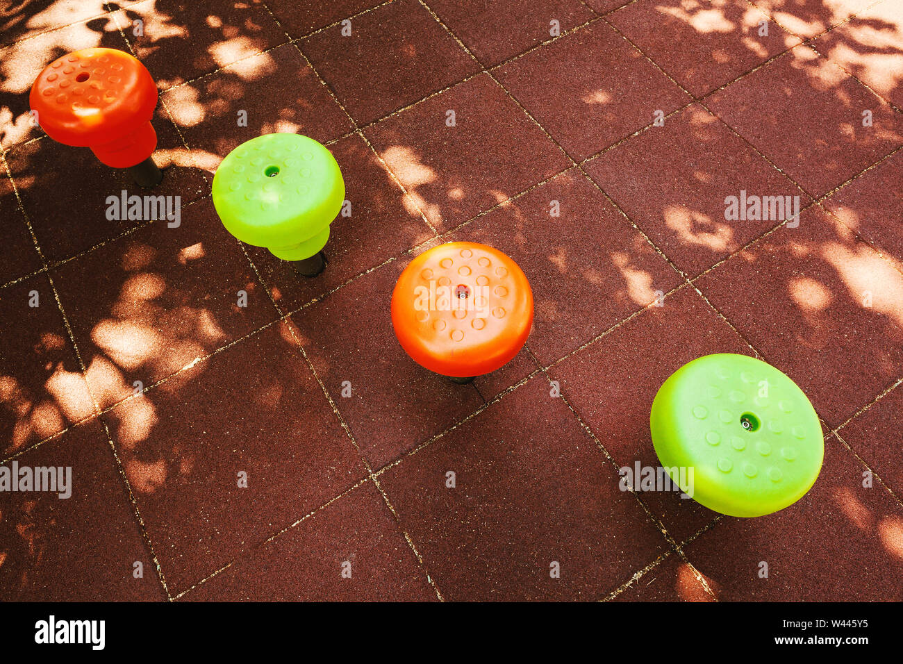 Parte del parco giochi, verde e arancione di fasce battistrada sulla superficie gommata. Foto Stock