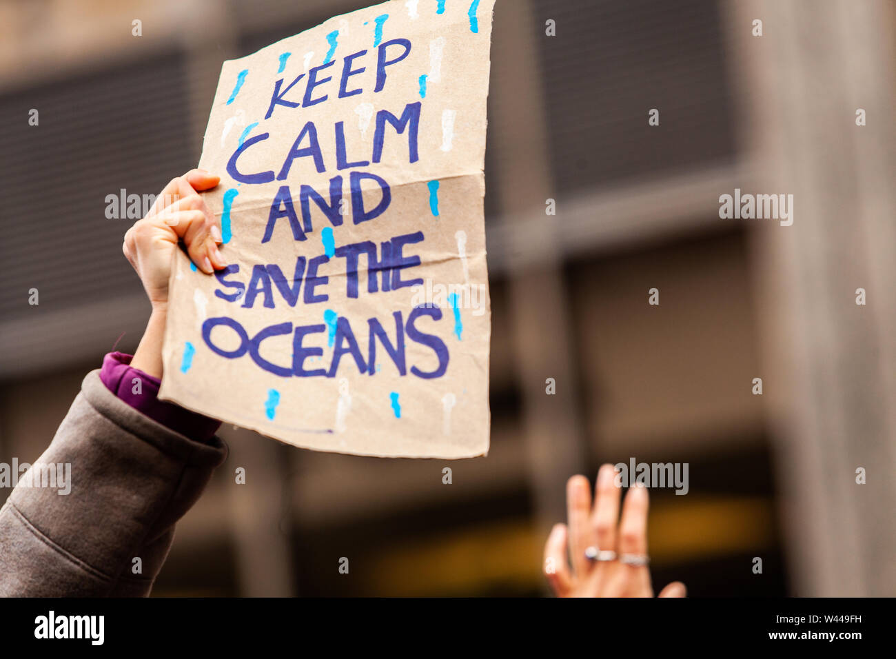 Una vista ingrandita di un segno di cartone dicendo di mantenere la calma e salvare gli oceani durante un cambiamento climatico rally nel centro della citta'. Protesta ambientale. Foto Stock