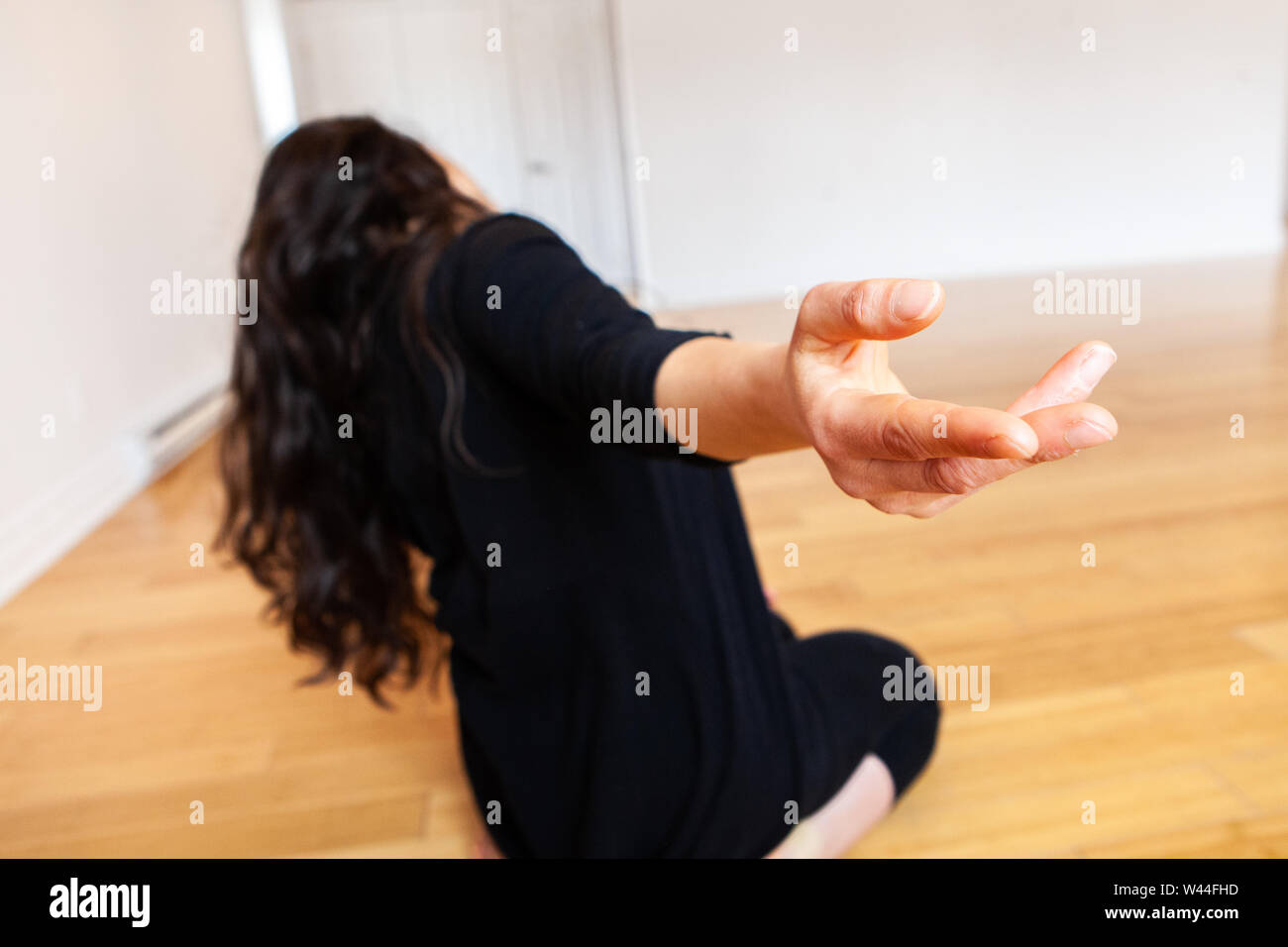 Una vista ravvicinata della mano di una ragazza caucasica come lei esegue la danza emotiva si muove da solo in un monolocale, il suo corpo sfocata è visto in background. Foto Stock