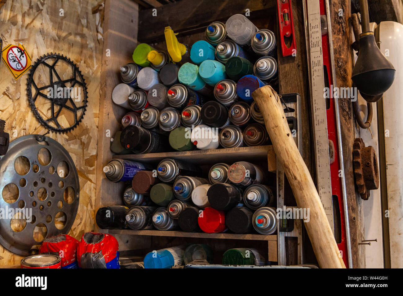 Un primo piano di molti aerosol pressurizzato teglie memorizzati su scaffali in legno all'interno di un workshop. Foto Stock