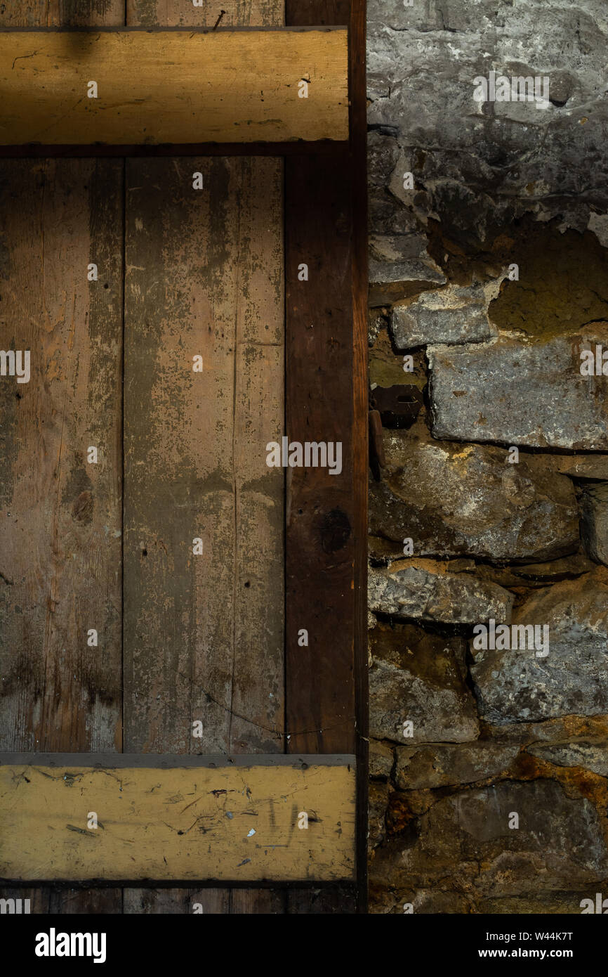 Vecchia porta di legno e muro di pietra nel vecchio magazzino nel seminterrato. Foto Stock