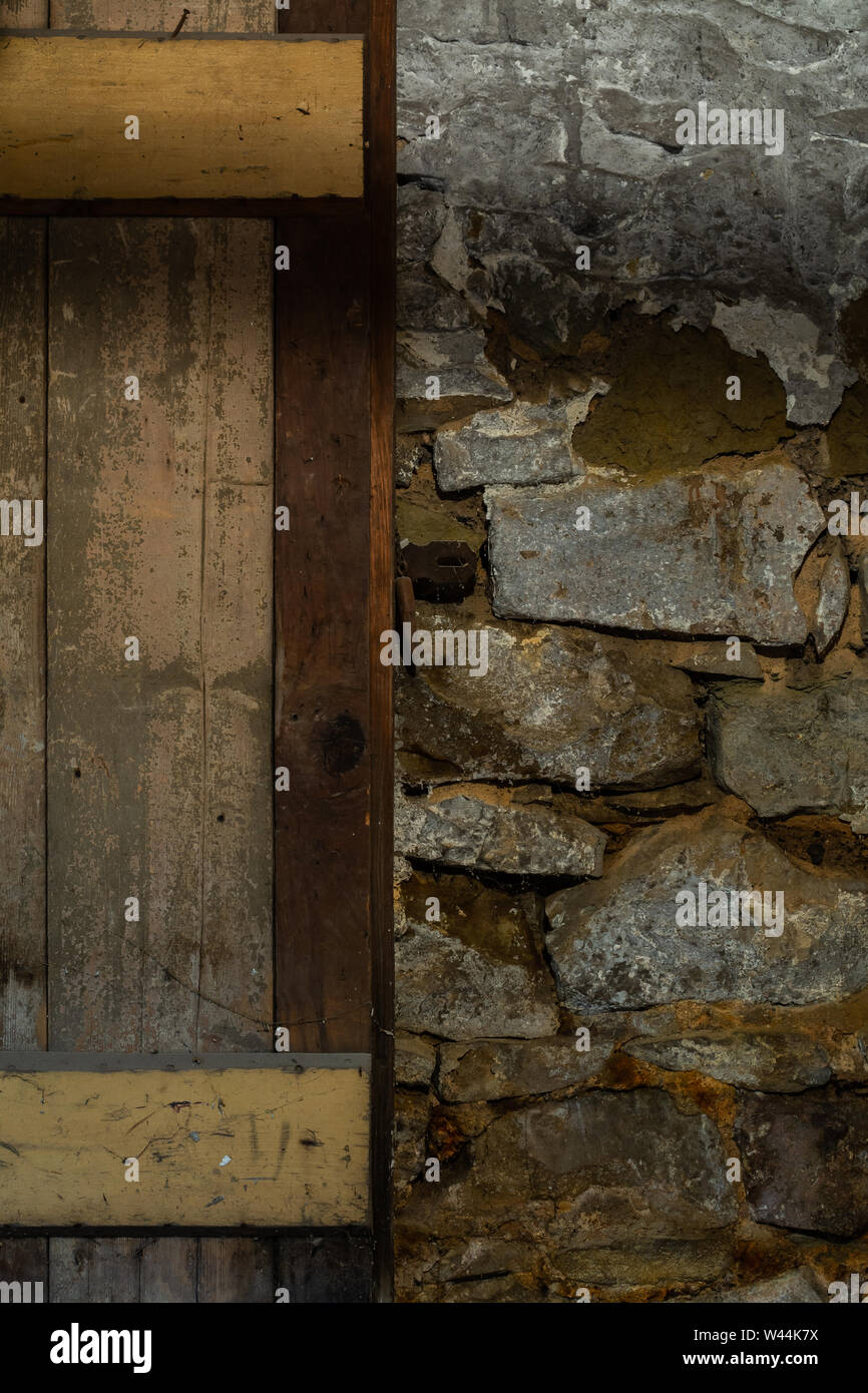 Vecchia porta di legno e muro di pietra nel vecchio magazzino nel seminterrato. Foto Stock
