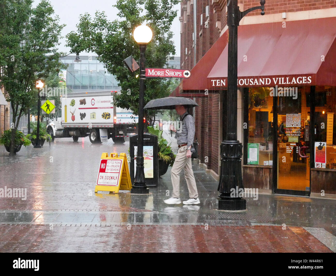 Acquazzone, Oak Park, Illinois. Uomo con ombrello. Foto Stock