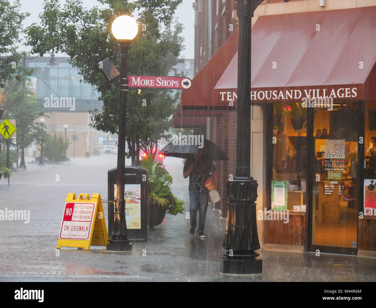 Acquazzone, Oak Park, Illinois. Uomo con ombrello. Foto Stock