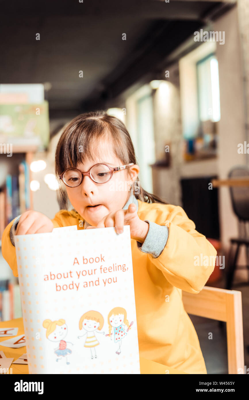 Curioso il capretto con problemi di salute che si occupano di nuovo libro Foto Stock