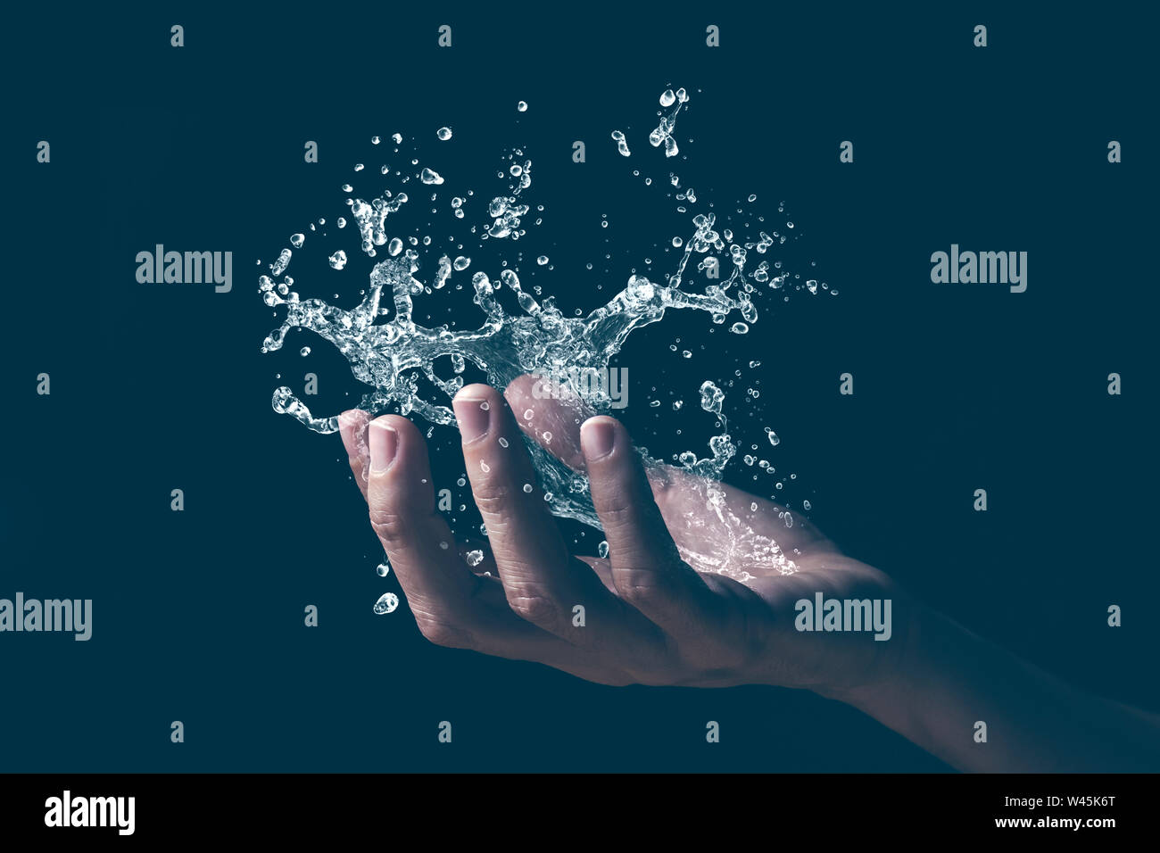 Una mano umana tenendo un schizzo d'acqua. Foto Stock