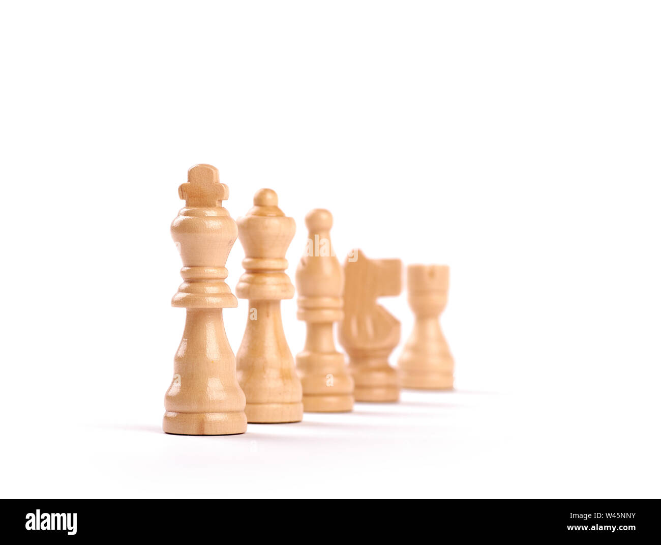 Riga di legno bianco pezzi di scacchi con il fuoco selettivo isolato su sfondo bianco. Foto Stock