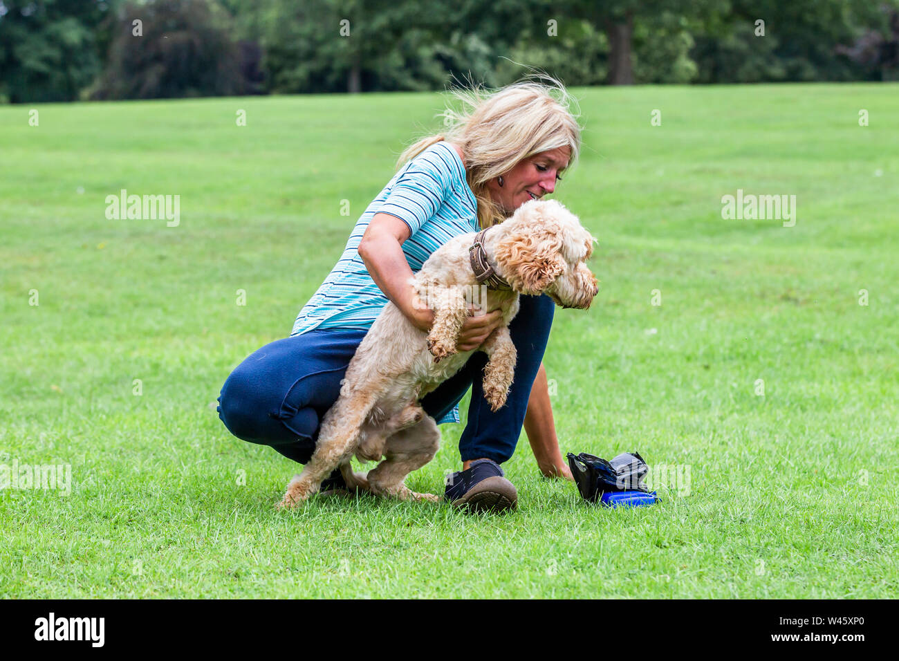 Northampton UK. Il 20 luglio 2019. Meteo. Abington Park. Una bionda signora dai capelli divertendosi con il cane sulla passeggiata mattutina, previsioni per pioggia è più tardi nella giornata. Credito: Keith J Smith./Alamy Live News Foto Stock