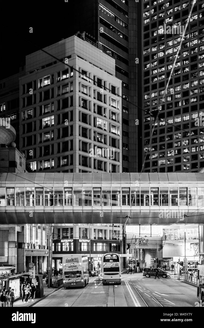 Hong Kong Cina - Marzo 15 2019: tram, autobus e auto drive in Isola di Hong Kong con il quartiere centrale degli affari di notte lungo il lusso Des Voeux Roa Foto Stock