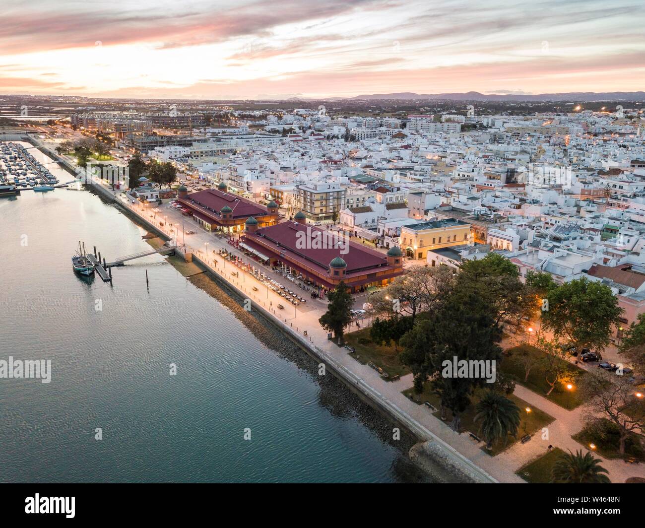 Vista città con due edifici di mercato di sera, fiume Ria Formosa, Olhao, Algarve, PORTOGALLO Foto Stock