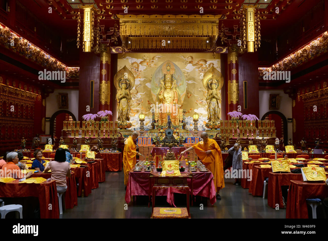 Durante le preghiere del mattino nella simbolica del Dente del Buddha Tempio reliquia & Museum a Chinatown, Singapore, i sacerdoti svolgono un rituale di fronte al santuario principale Foto Stock