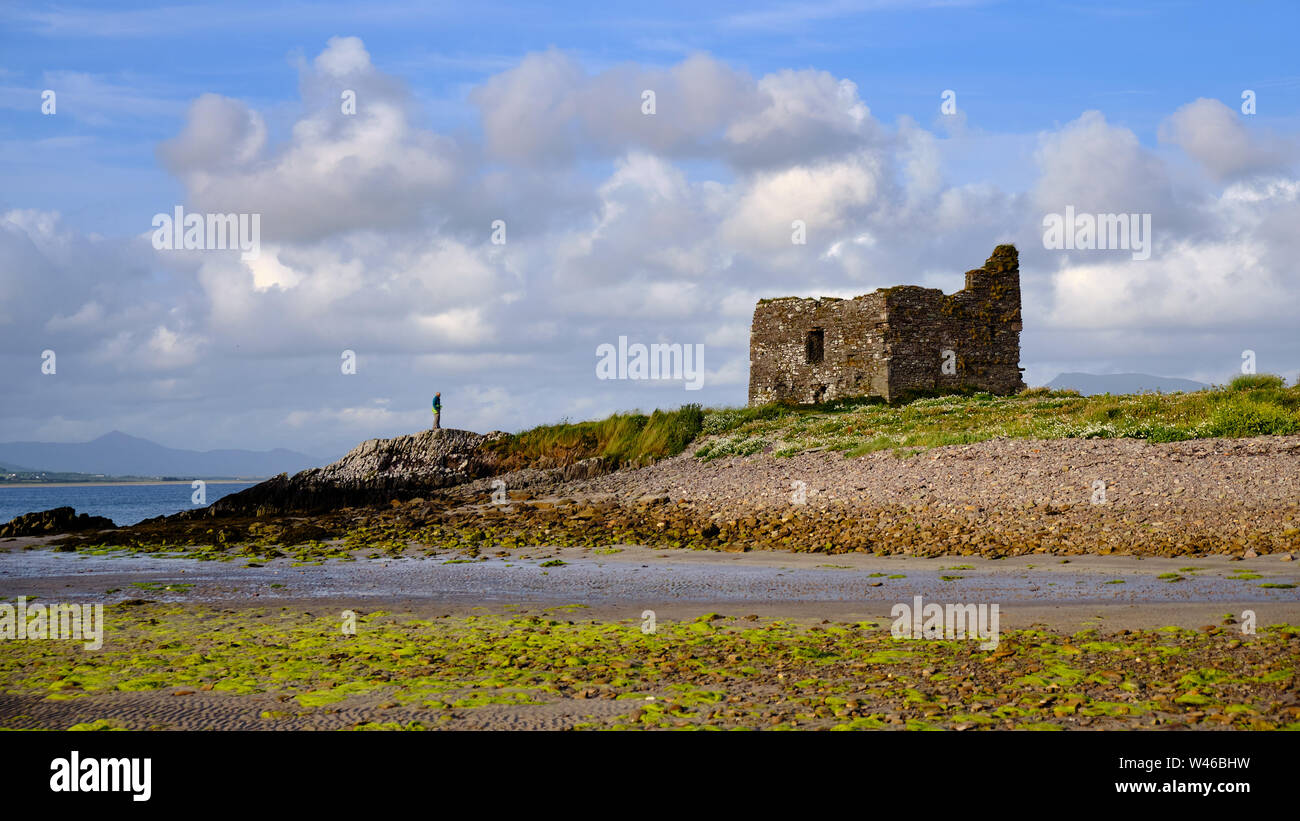 McCarthy Mor Casa Torre Ballinskelligs Castello con figura solitaria in piedi vicino. Baile un Sceilg, nella contea di Kerry, Irlanda Foto Stock