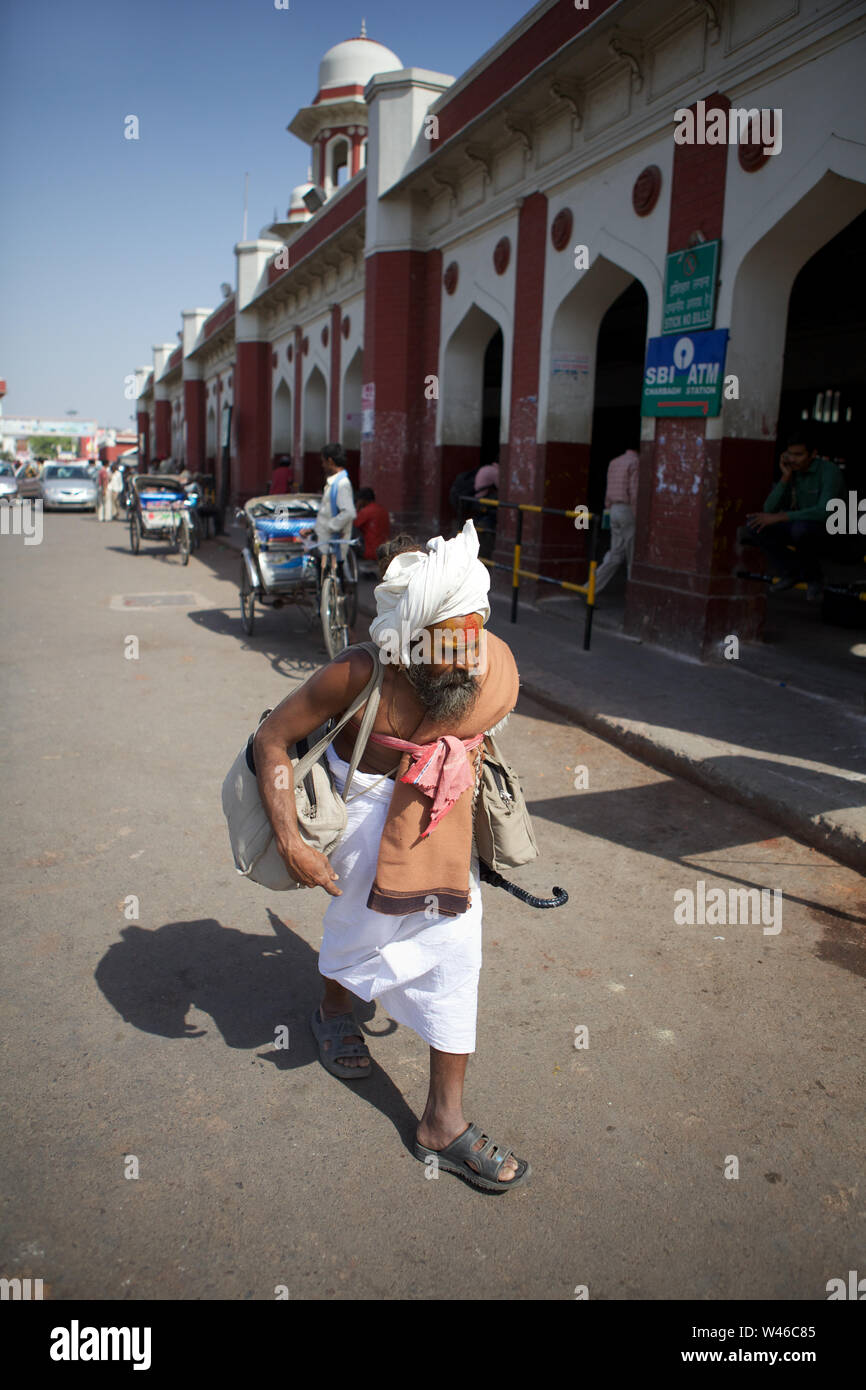 Sadhu camminando di fronte ad una stazione ferroviaria, Lucknow, utter Pradesh, India Foto Stock