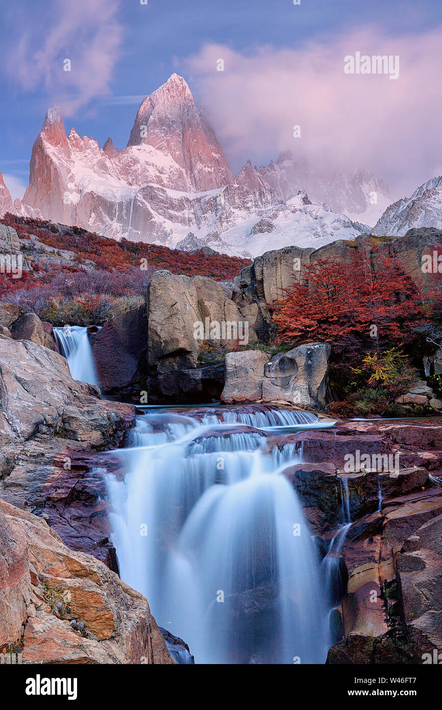 Una piccola cascata e del bosco di faggio all'alba . La parte superiore di Fitzroy e le nuvole sono colorate dal sole illumina di colore rosso. Parco nazionale Los Glaciares. Foto Stock Una piccola cascata e del bosco di faggio all'alba . La parte superiore di Fitzroy e le nuvole sono colorate dal sole illumina di colore rosso. Parco nazionale Los Glaciares. Foto Stock