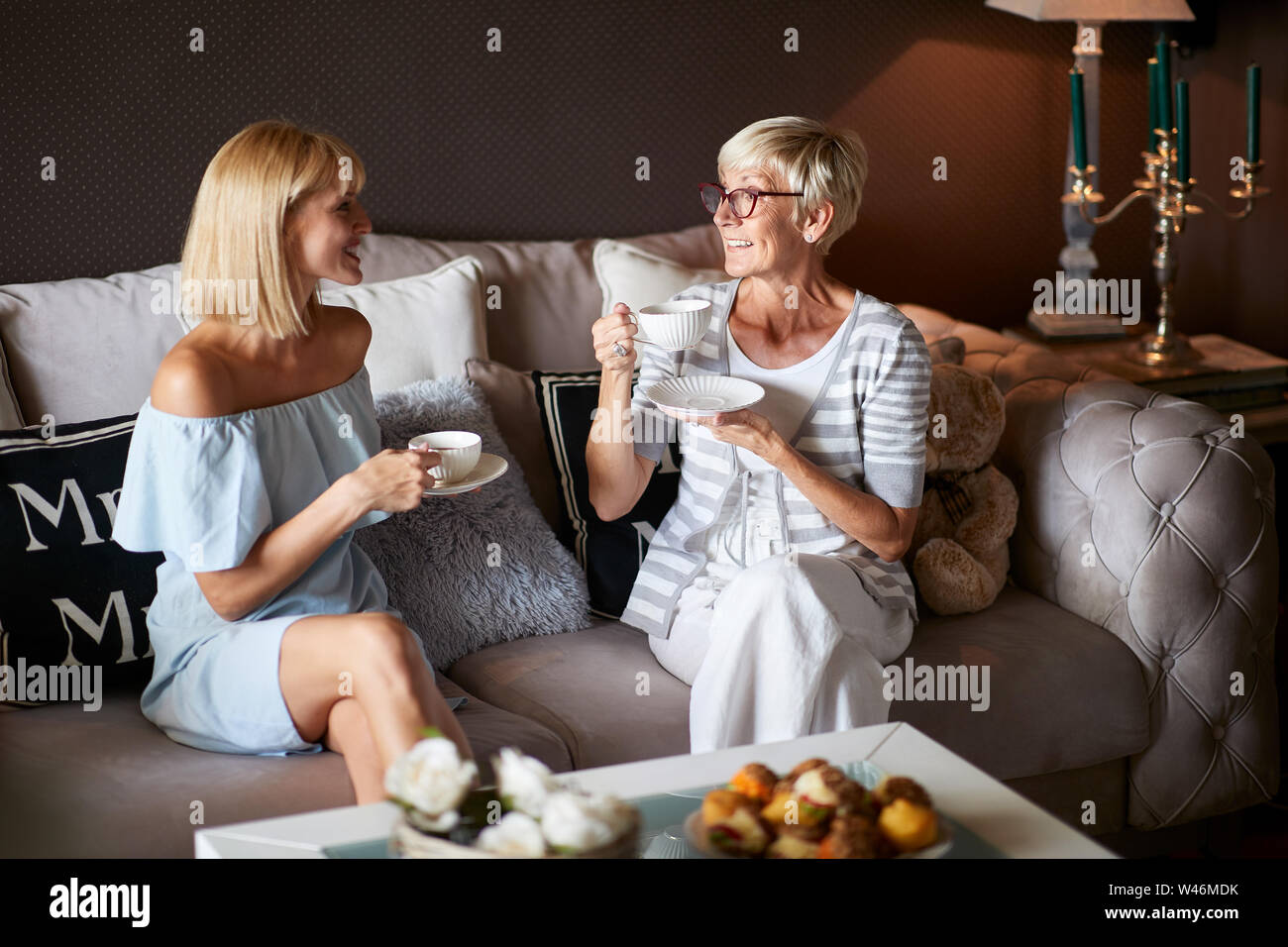 Due donne in piacevole parlare con la tazza di caffè a casa Foto Stock