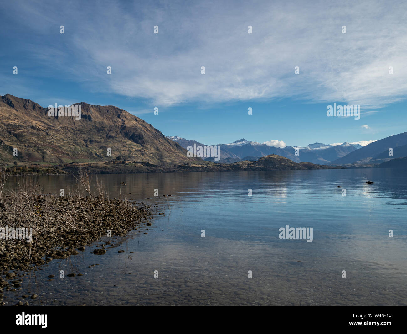 Vista del lago Wanaka e alpi del sud in autunno con neve sulle cime, e riflessi nell'acqua Foto Stock