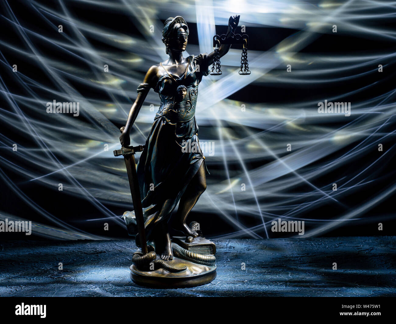 Themis statuetta sorge sul vecchio vintage tavolo di pietra. La foto è stata scattata con un pennello di luce - Immagine Foto Stock