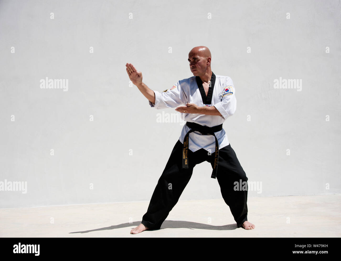 La cintura nera Sensei istruttore di arti marziali dimostrando Taekwondo modulo. Egli è un maestro e istruttore come indicato dalla sua uniforme e forma. Foto Stock