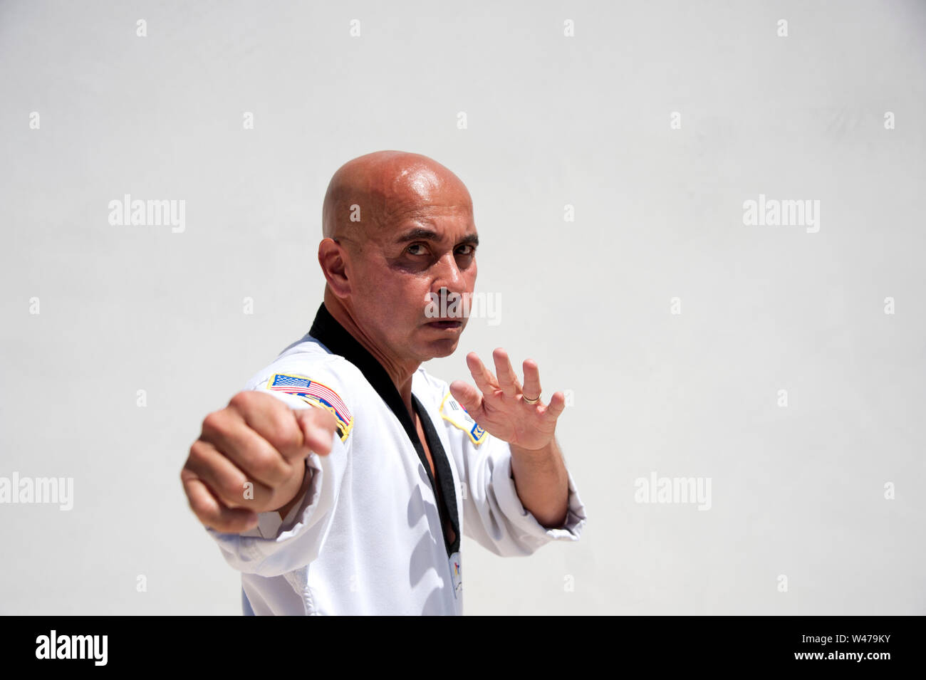 La cintura nera Sensei istruttore di arti marziali dimostrando Taekwondo modulo. Egli è un maestro e istruttore come indicato dalla sua uniforme e forma. Foto Stock
