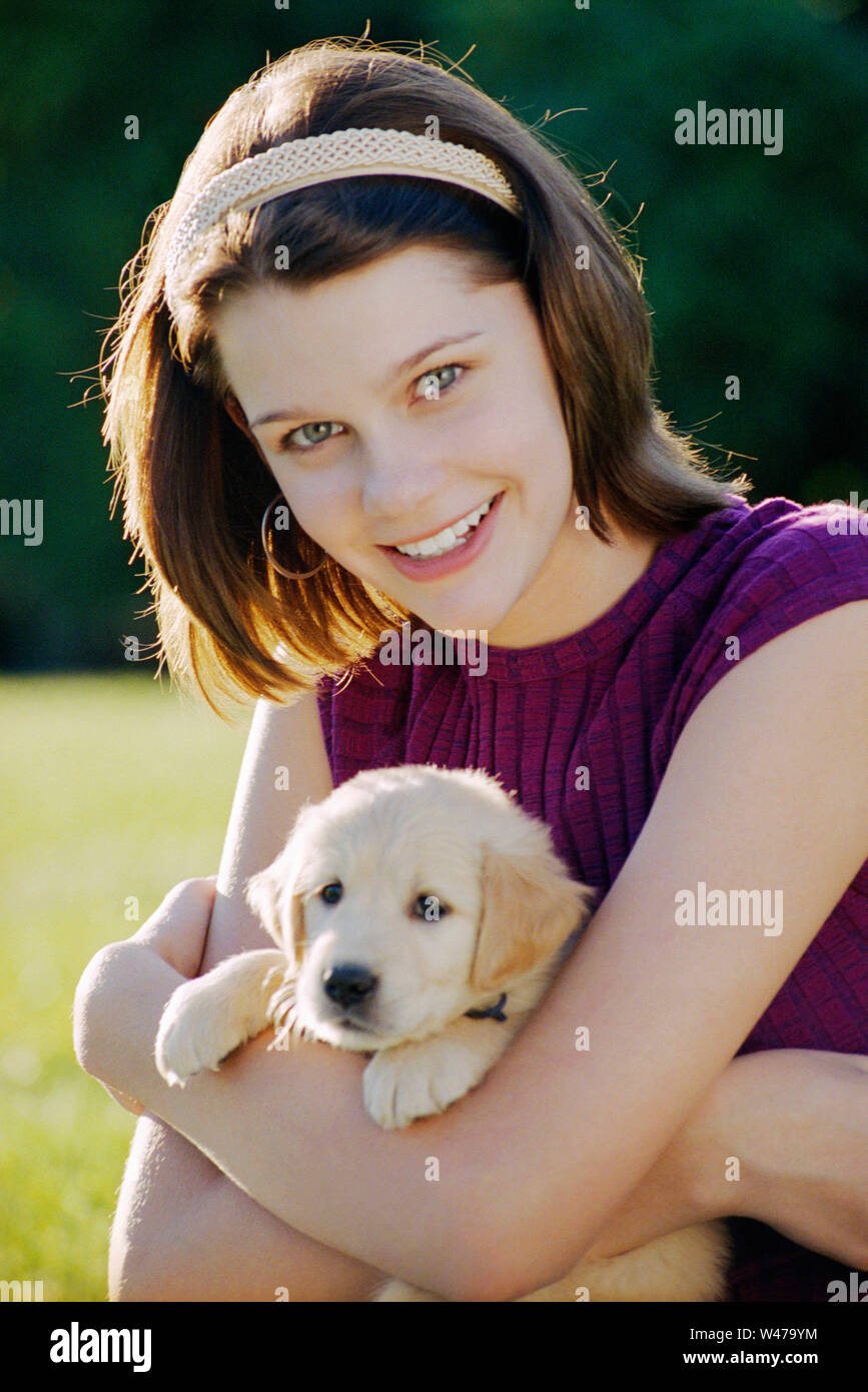 Donna che abbraccia cucciolo di cane Foto Stock