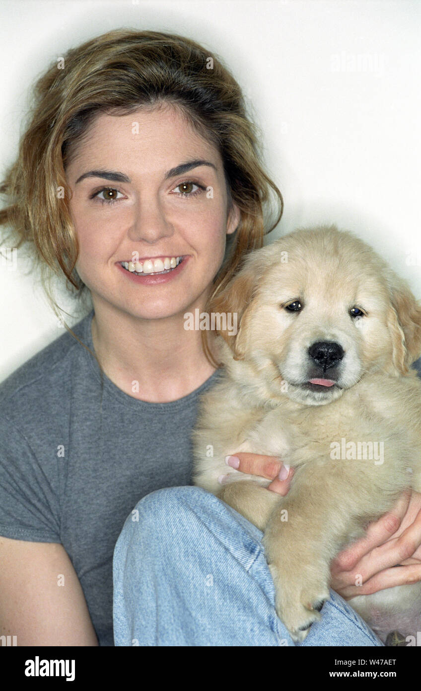 Una donna con il golden retrieverPuppy Foto Stock