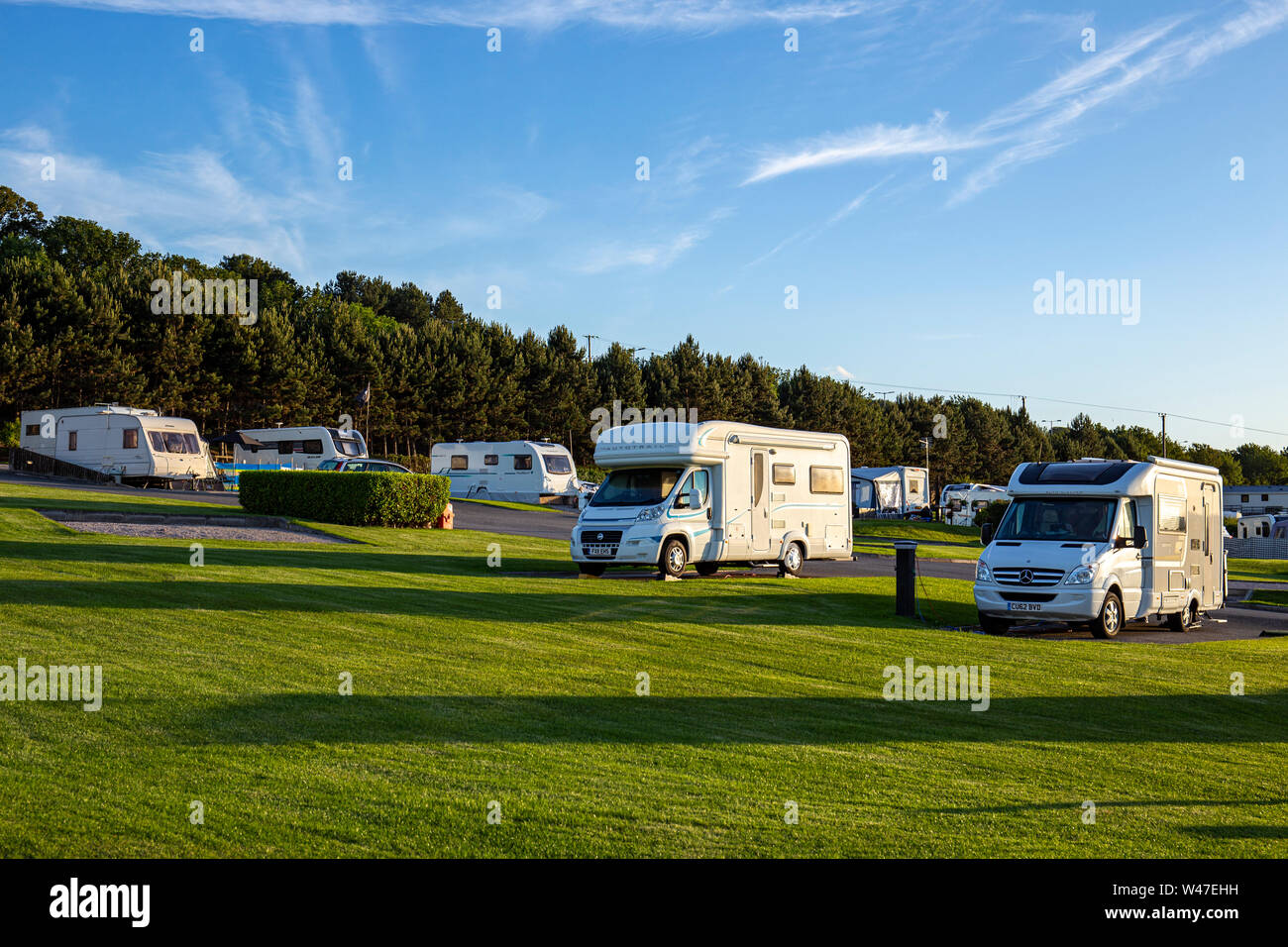 A tarda sera sun con camper e roulotte in un campeggio nel Galles del Nord Regno Unito Foto Stock