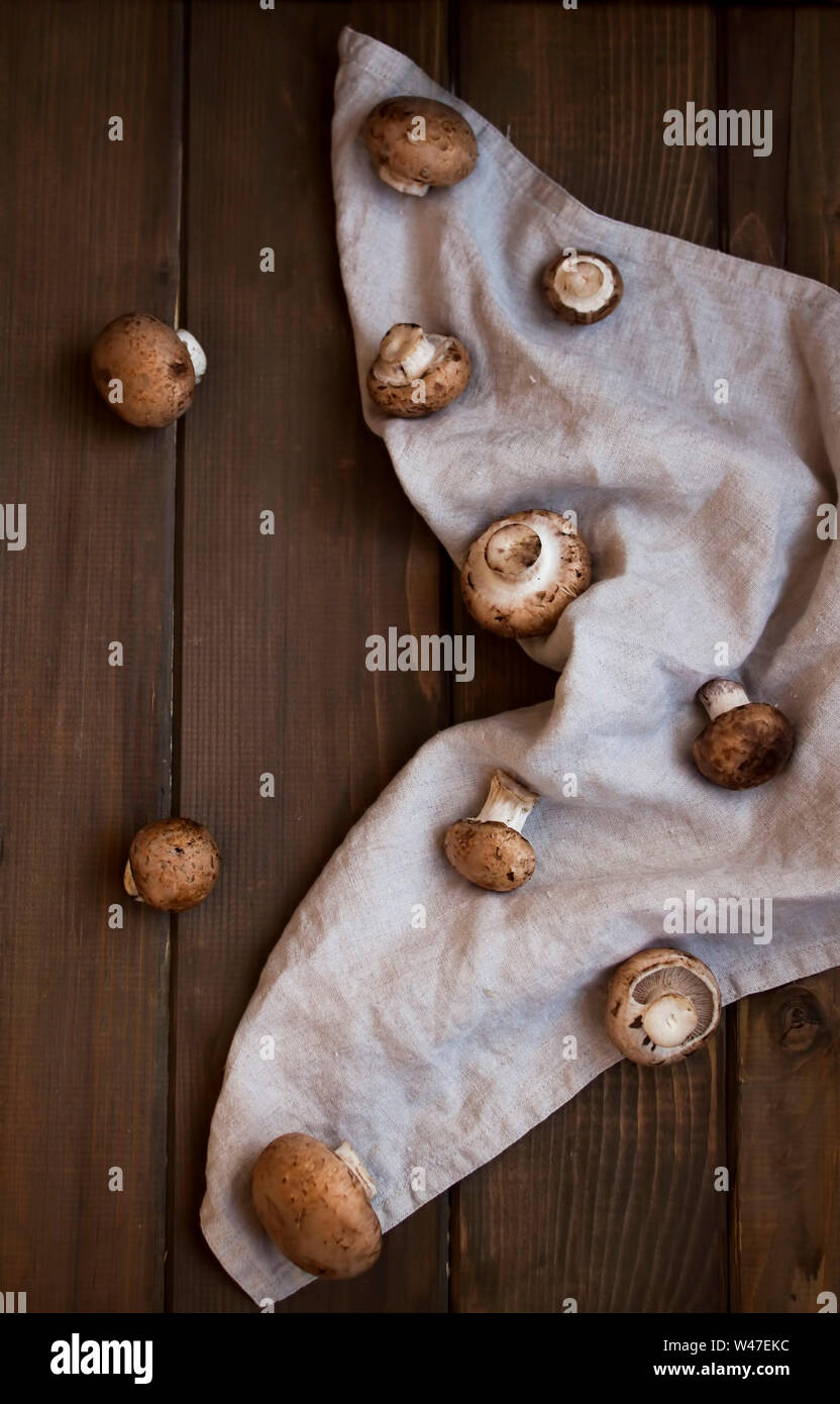 Poco champignon marrone sul rustico in legno sfondo. Foto Stock