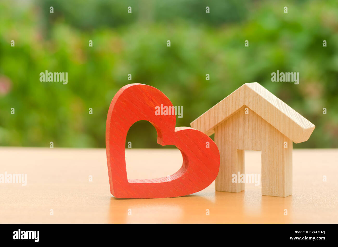 Casa con un rosso cuore di legno. Casa di amanti. Abitazioni a prezzi accessibili per le giovani famiglie, programma di sostegno. Parental casa ospitale. La costruzione di abitazioni Foto Stock