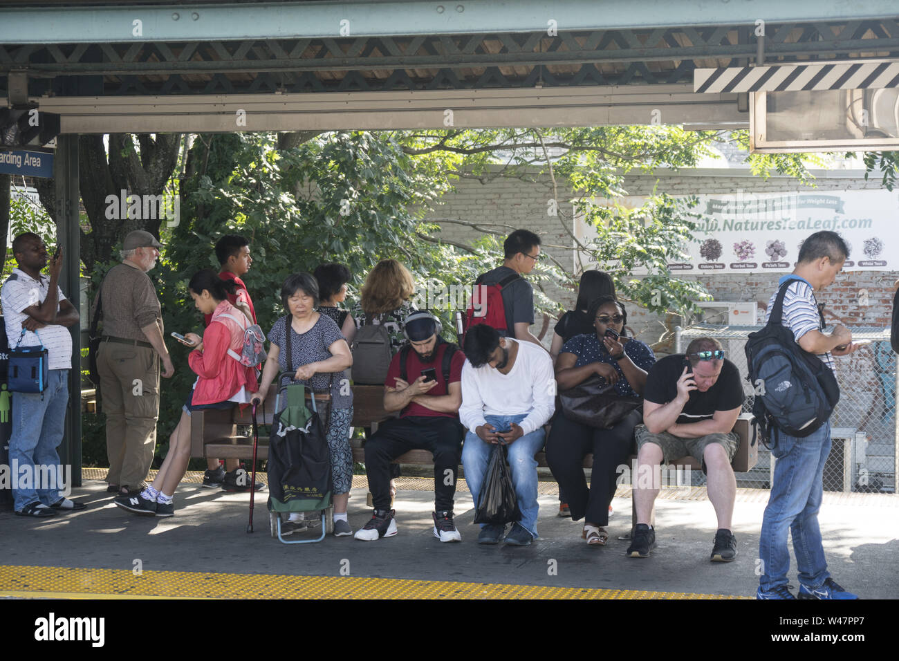 La gente in attesa di un treno della metropolitana nella suddetta stazione di terra al Kings Highway in Brooklyn, New York. Foto Stock La gente in attesa di un treno della metropolitana nella suddetta stazione di terra al Kings Highway in Brooklyn, New York. Foto Stock