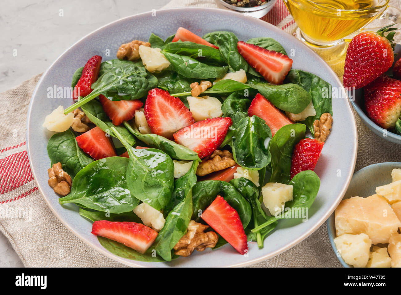 Estate insalata di fragole con foglie di spinaci, formaggio parmigiano, olio di oliva e noci. sana dieta cheto cibo. close up Foto Stock