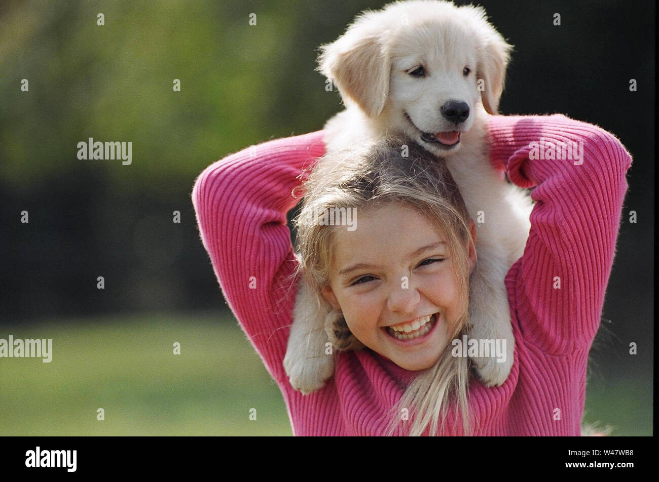 Giovane ragazza in piedi tenendo un cucciolo intorno a lei le spalle Foto Stock