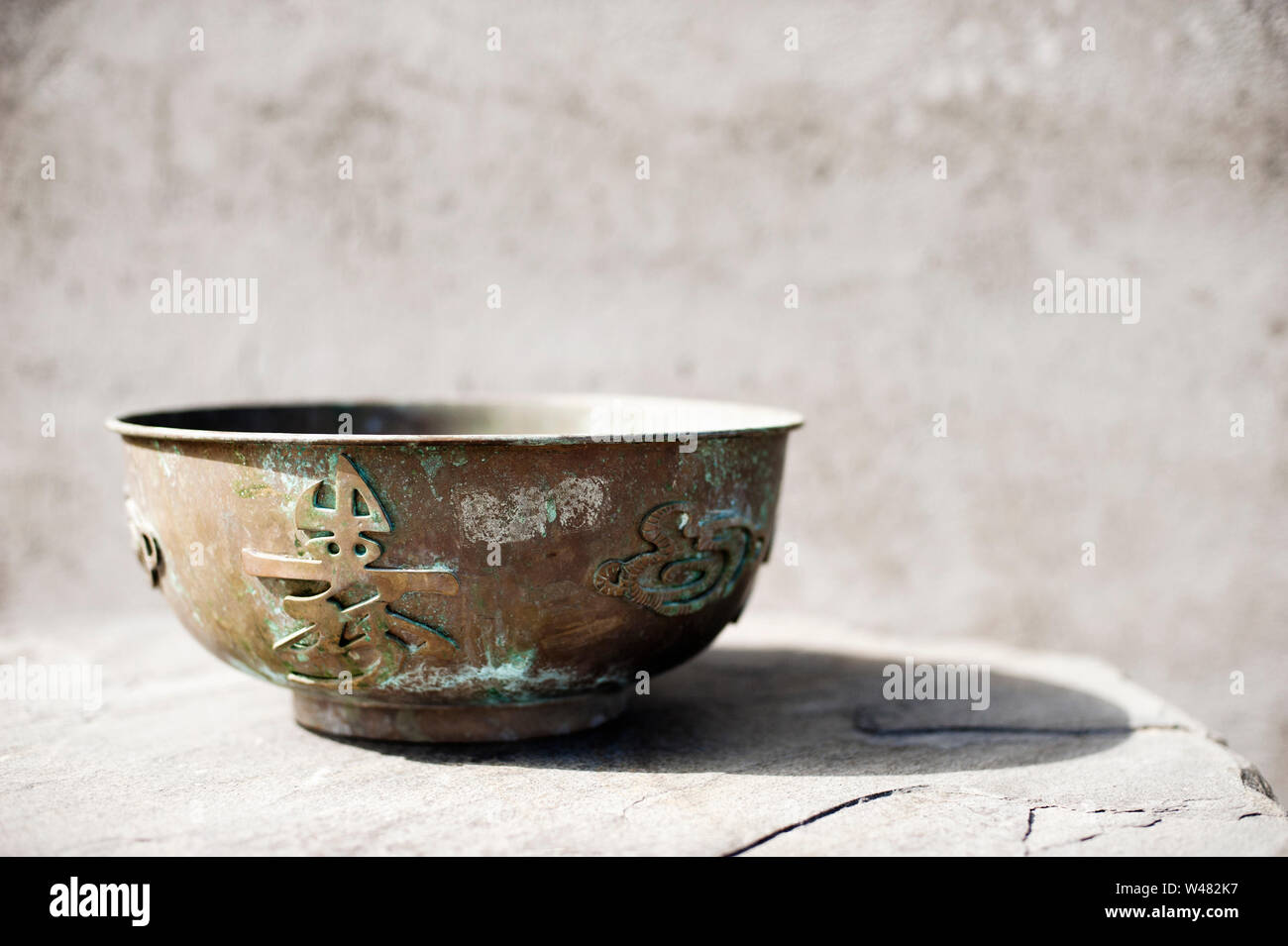 Cinese ciotola di metallo con una bella patina e calligrafia e elemento di drago. Foto Stock